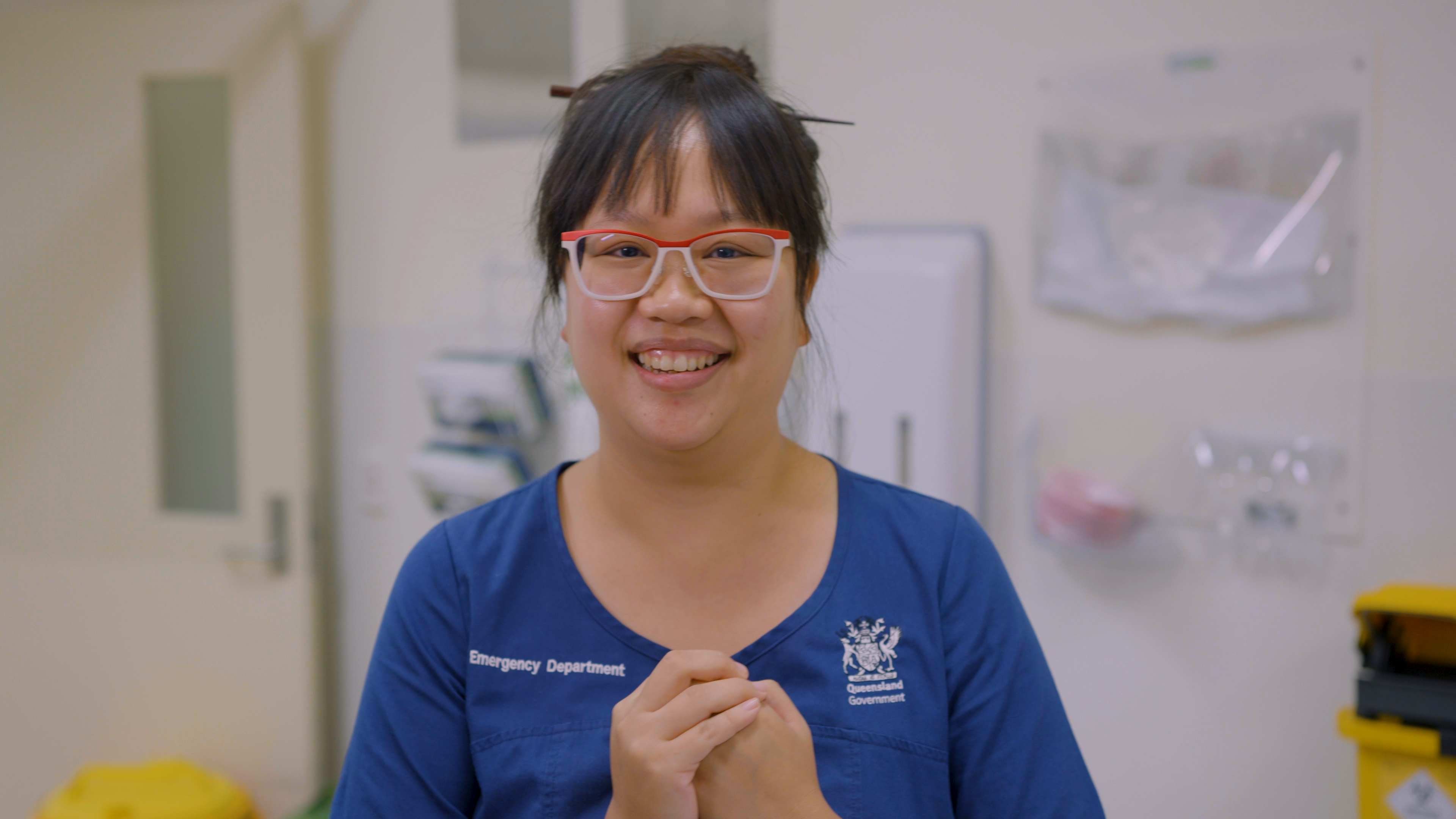 Doctor wearing scrubs smiles at the camera