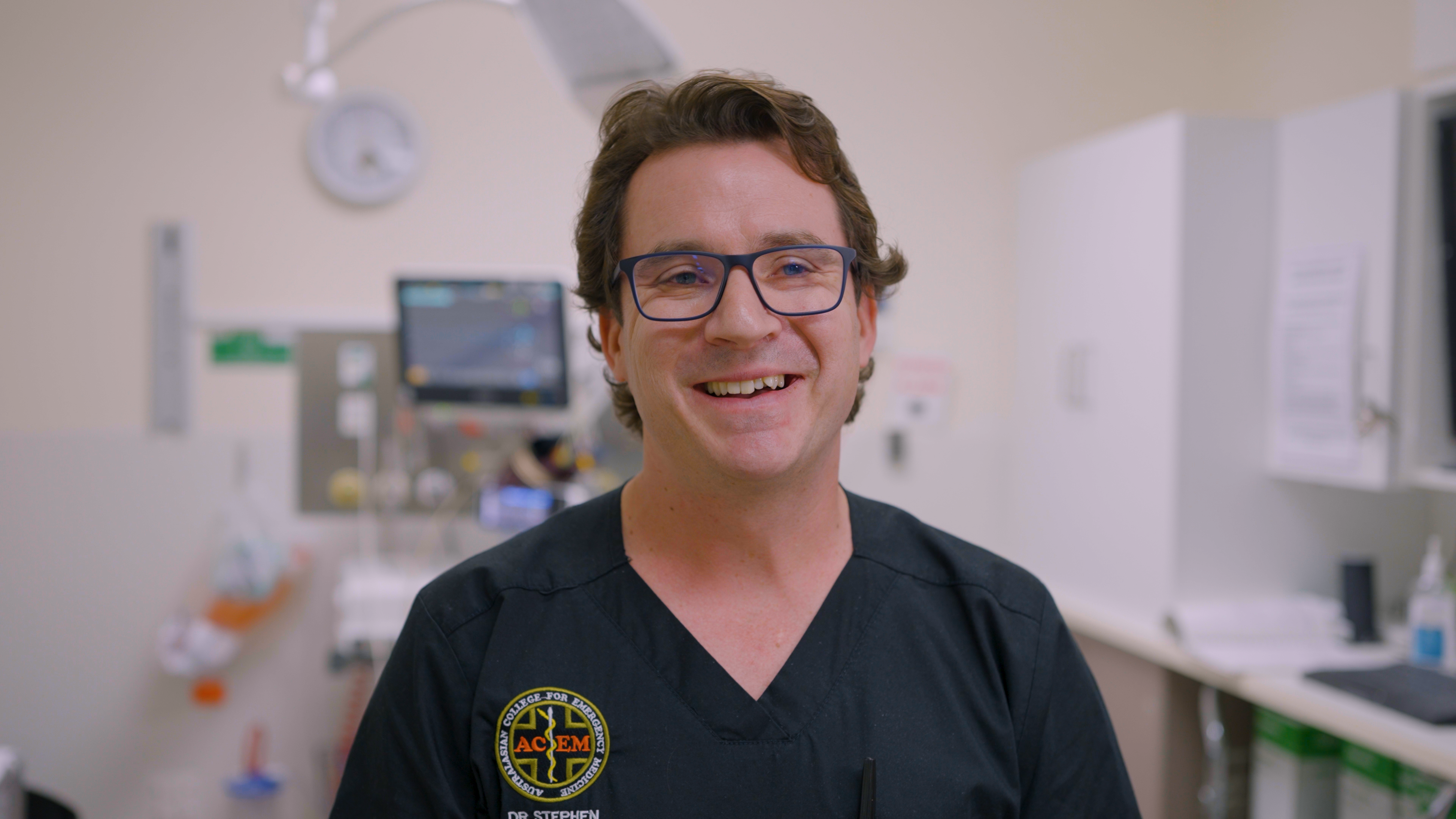Male doctor smiles at camera